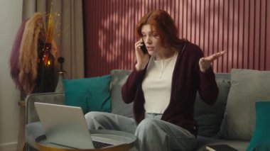 Stresli kadın işkadını kızgın Kafkasyalı serbest çalışan kız bilgisayar çalışıyor evde çalışıyor rahatsız iş kadını koltukta cep telefonuyla konuşuyor tartışma sorunu tartışılıyor