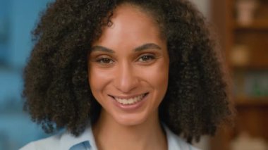 Mutlu Afro-Amerikan kadın kameraya bakıp gülümsüyor. Yüzünde gülümseme, sağlık, anne, baba, kız, dişçilik, dişçilik, dişler, zarif bayan makyajı.