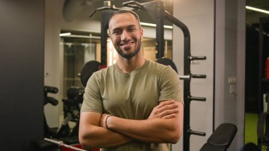 Hareket eden zoom kamera güçlü Afrikalı Amerikalı erkek fitness antrenörü spor sporcusu sporcusu olmaya davet ederek spor salonuna davet ediliyor.