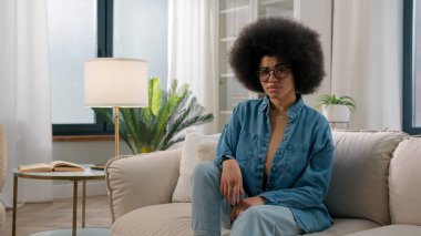 Ciddi, kendinden emin, Afro-Amerikalı bir kadın kanepeye oturmuş parmağını sallıyor hayır asla olumsuz cevap vermeyi yasaklamıyor reddediyor, reddediyor.