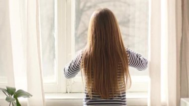 Küçük kız penceresi sağlıklı saçları sallıyor kameraya bakıyor mutlu çocuk evine bakıyor eğlenceli çocuk pozitif öğrenci kız öğrenci kız öğrenci memnun kız kıza hafta sonu keyfi yapıyor tatilde rahatla