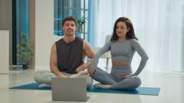 Erkek ve kadın çift olarak sevgili, yoga minderlerinde oturan erkek arkadaş, dizüstü bilgisayarda spor salonu teknolojisini selamlıyor güçlü fitness aerobik jimnastik motivasyon buluşması bağlantısını konuşuyorlar.