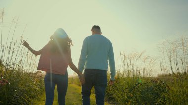 Arkadan bakan sevimli beyaz çift, aile kızı, kız arkadaş, el ele tutuşan sevgili erkek, erkek kırsal alanda yürüyüş yapan tatilin tadını çıkarın.