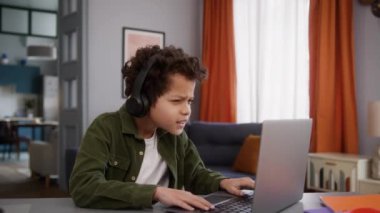 Afrikalı etnik çocuk çocuk çocuk çocuk kullanıcı online internet oyunu dizüstü bilgisayar oyunu oynuyor evde kulaklıkla bilgisayar oyunu oynuyor başarısızlığı kötü sonuç kötü tepki bağımlılığı başarısız