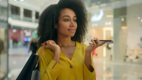 stock image African American ethnic woman talking mobile phone smartphone chatting voice message holding paper bags shopping mall weekend technology call using gadget cheerful girl buyer style shopaholic indoors