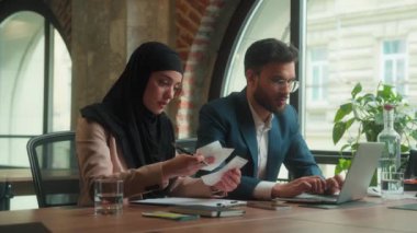 Hüsrana uğramış üzgün iş ortakları ofis arkadaşları Arap erkek Müslüman kadın tesettür işkadını fatura sayma sorunu kötü mali sorun iflas kaybı
