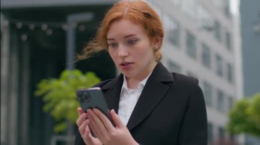 Üzgün genç Kafkasyalı iş kadını kadın öğrenci iş kadını cep telefonu kullanıcısı akıllı telefon aygıtı arızası şehir merkezindeki kötü haber sorunlarını strese sokuyor