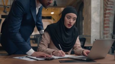 Müslüman kadın tesettürcü kadın işkadını ofis bilgisayarında çalışan Arap erkek işadamı erkek işadamı akıl hocası çalışanın iyi bir işi onaylamasına yardımcı oluyor mutlu takım çalışmalarını tebrik ediyoruz