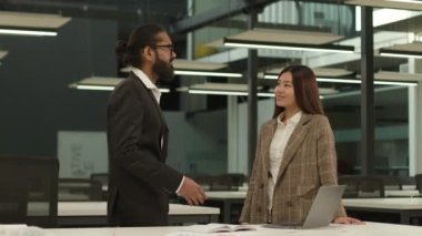 Asyalı iş kadını Koreli kadın yönetici kadın Arap işadamı Hintli işadamı CEO 'su iki iş arkadaşı ile konuşuyor.