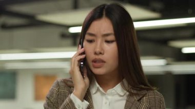 Asyalı iş kadını, iş kadını Koreli yönetici, işkadını, işveren, ofis içinde çalışan bir kız, müşterilerle telefonda konuşuyor, kötü telefon bağlantısı sorunu, düşük sinyal duyma sorunu.