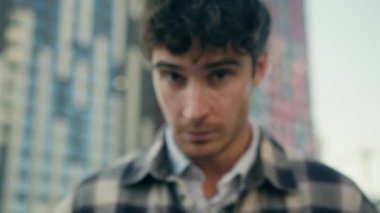 Açık havada, beyaz, yetişkin 30 'lu yaşlarda erkek. Yüzü asık, üzgün, üzgün, mutsuz, turist bakışlı, şehir merkezindeki emlakçı iş adamı müşterisinin dışında gezen erkek.