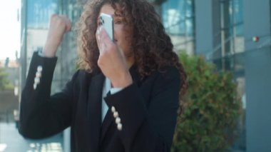 Heyecanlı, mutlu, Kafkasyalı iş kadını coşkulu haberi kutluyor. Harika bir cep telefonu mesajı alıyor. İyi haber.