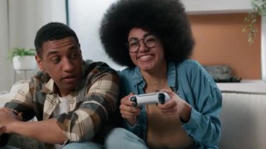 Afrikalı Amerikalı çift internet oyunu bağımlısı üzgün erkek arkadaş, erkek arkadaş, mutlu kadın, kız arkadaş, oyun kumandası, oyun konsolu, oyun konsolu, oyun konsolu.