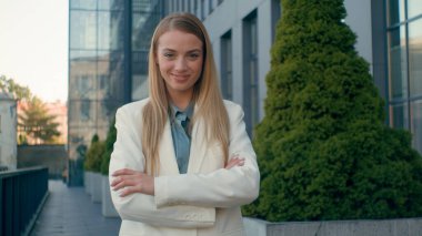 Şehir merkezindeki mutlu beyaz iş kadını kadın mutlu yönetici kamerayı göstererek iş jestine katıldın. Kendinden emin gülümseyen öğrenci kız el sallayarak el sallıyor.