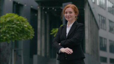 Neşeli, güler yüzlü, kızıl saçlı, beyaz, iş kadını, İK müdürü, bayan bayan, şık takım elbiseli, kamera seni el hareketine davet ediyor.