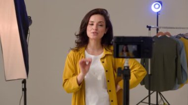 Kendine güvenen beyaz kadın kadın vlogger video blogunu kaydediyor profesyonel kamera tripod dengeleyici teknolojisini kullanıyor. Kadın blogcu sözü, stüdyoda canlı yayında konuşuyor.