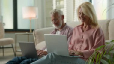 Mutlu, yaşlı, beyaz, erkek, kadın, dizüstü bilgisayar kullanıyor. Uzaktan kumandalı, erkek, kadın, bankacılık, internet, e-ticaret, karı, koca, kanepe, aile, bağımlı ev.