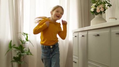 Küçük mutlu kız dans ediyor şarkı söyleyen kız çocuğu neşeli çocuk eğlencesi kutluyor hafta sonu gülümsüyor heyecanlı hareket çalışıyor atlama hareketleri çalışıyor enerjik ifade duyguları aktif bebek sabahı