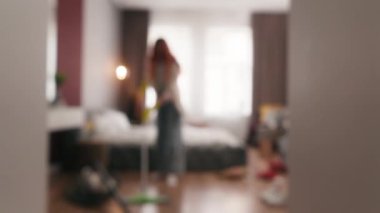 Odaklanmamış bulanık kadın evi temizliyor kadın ev kadınını temizliyor ev hizmetçisi temizlikçi yatak odasındaki paspasla yerleri yıkıyor ev işleri düzenli temizlik yapıyor