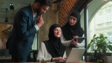 Erkek kadın patron akıl hocası iş kadını iş kadını tesettürdeki Müslüman kadınlar yeni ofis çalışanına danışmanlık öğretmeye yardımcı olur. Laptop projesinde yardımcı olur şirket çalışanı kızlar erkek işbirliği yapar.