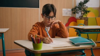 İlkokula geri döndüm. Kafkasyalı erkek çocuk, çocuk, okul çocuğu, sınıf dersi öğrencisiyim. Yazma ödevi, matematik, kalem sınavı öğreniyorum.