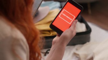 Üzgün, tanınmayan, elinde telefon olan bir kadın uçuş mesajını iptal et. Havaalanını iptal et. Uçağı iptal et.