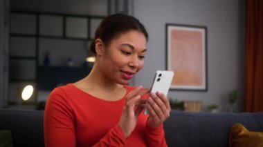 Cep telefonu yazan Afro-Amerikalı hamile kadın cep telefonu satın almayı seçti. İnternet üzerinden alışveriş yapan cep telefonu uygulaması sipariş yoluyla sosyal medya akıllı telefonu taraması yaparak ev kanepesinde dinleniyor.