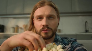Kafkasyalı yalnız erkek adam TV şovu ilginç bir film programı izliyor abur cubur yiyor patlamış mısır yiyor hafta sonu tatilini evde geçiriyor çevrimiçi film bağımlısı oluyor.