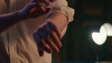 Tanınmayan adam işini bitirdiği gün karanlık ofis tekstili şık iş adamı stili kıyafet lüks kıyafetler giyip kolları sıvayıp resmi gömleğin yakasını düzeltiyor.