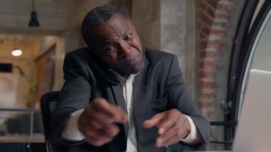 Öfkeli Afrikalı Amerikalı yetişkin yönetici ofis işadamı stresli işadamı işvereni kızgın erkek dizüstü bilgisayar hatası kağıtlar iş problemini cep telefonu tartışmasını belgeliyor