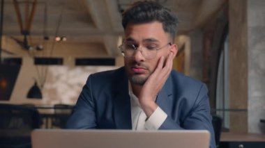 Sıkıcı Arap iş adamı ofiste dizüstü bilgisayarda çalışıyor yorgun, bitkin, bıkkın, çalışanı üzgün, depresyondaki erkek işadamı, sıkıcı, sıkıcı, can sıkıcı iş yeri.