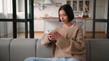 İspanyol kadın mutlu bayan kullanıcı ev mutfağında cep telefonu uygulamalarına bakıyor internetten sosyal medya alışverişi yapıyor gülüşmeler, akıllı telefon bağımlısı alıcılar internet siparişi kullanıyor.