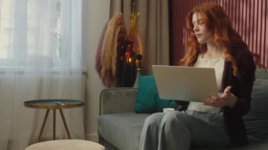 Kafkasyalı kadın ev sahibi, serbest çalışan kız öğrenci, uzaktan bilgisayar kullanan, bilgisayar kullanan, internetten alışveriş yapan, internetten alışveriş yapan, kahve içen, rahatlayan bir film izleyen.