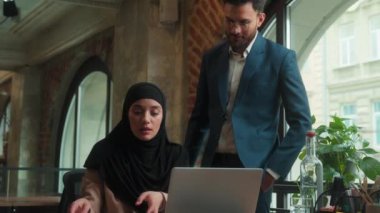 Arap erkek patron akıl hocası hoşnutsuz erkek işadamı konuşmaları kadın işçiye kızgın başarısız sonuç sorun iş belgeleri tesettüre gelen tesettürlü Müslüman kadın üzgün ofis masasında