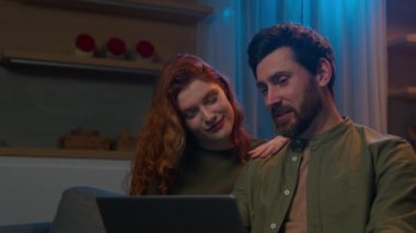 Aşık beyaz bir çift. Kadın karı koca, evinde dizüstü bilgisayar kullanıyor. Keyfini çıkarın. İnternet 'te e-ticaret servis planlama biletlerini kullanarak online mağazadan satın alın.