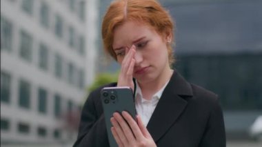 Sinirli, Kafkasyalı, kızıl saçlı, iş kadını, kız, öğrenci, girişimci cep telefonu kullanıyor, endişeli, işten çıkarılmış iş sorunları şehir dışında başarısız sınav sonuçları alıyor.