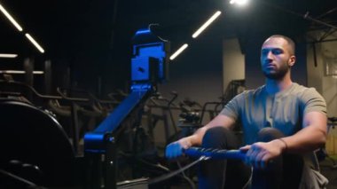 Spor amaçlı egzersiz kasları sırt kasları sağlıklı Afrikalı Amerikalı antrenör güçlü erkek sporcu vücut geliştirme sporcusu halat çekme, kürek çekme makinesi oturma.