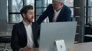 Başarılı bir şekilde heyecanlı Kafkas iş adamları ofiste bilgisayar ekranı arıyorlar iş ortakları birlikte iş başarısını kutluyorlar el sıkışıyorlar başarılı zaferi kutluyorlar