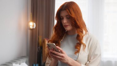 Şaşırmış Kafkas kadın çevrimiçi inanılmaz haberler okuyor cep telefonu akıllı telefonu kullanıyor kameraya bakan heyecanlı kadını hayrete düşürüyor.