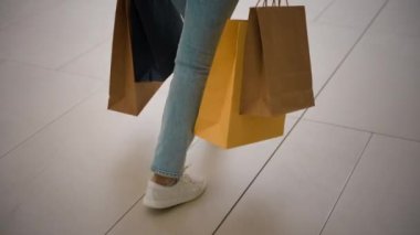 Tanımlanamayan beyaz kadın alışverişçi kadın ayakçı dükkanını kapatın. Elinde bir sürü çanta var. Kız müşteri kıyafet satın alıyor, Kara Cuma satışları kapalı alışveriş merkezlerine taşınıyor.