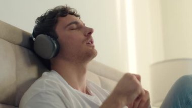 Kafkasyalı Avrupalı adam müzik dinleyen kulaklık teknolojisi ev kulaklıkları söylüyor hafta sonu dijital dinlenme aleti ses melodisi jesti ritim yaşam tarzı mp3 müzik listesi