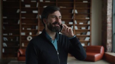 Mutlu gülümseyen beyaz sakallı, erkek, erkek, iş adamı, psikoterapist cep telefonu çağrı cihazı psikoloğu uzaktan danışmanlık bürosundan konuşuyor.