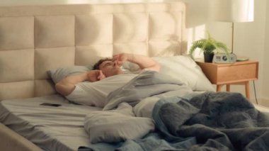 Kafkasyalı bir adam uyanıyor. Sabah yatak odasında uzanıyor. Gülümsüyor, tatmin oluyor. Erkekler hafta sonu uyukluyor, uyukluyor.