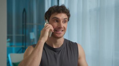 Kafkasyalı Avrupalı adam mutlu erkek sporcu cep telefonu siparişi iletim elektronik cihazı, neşeli vücut geliştirici kas teknolojisi sohbeti.