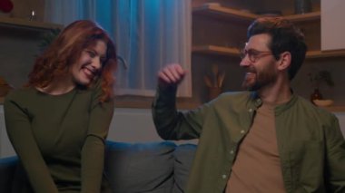 Değer veren adam dizüstü bilgisayarı kapatıyor. Kanepede sevgili kadına sarılıyor. Mutlu Kafkasyalı evli koca sarılıyor.