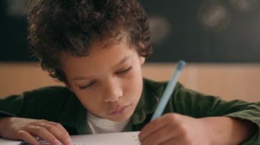 İlkokula geri döndüm. Afrika kökenli Amerikalı erkek çocuk, okul çocuğu çocuk, sınıf dersi öğrencisi. Matematik yazmayı öğreniyorum.