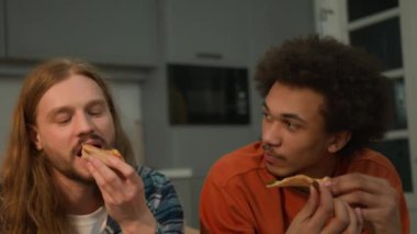 Mutlu çekimler, gülen, gülen, çok ırklı, farklı etnik çeşitliliğe sahip genç arkadaşlar, çok ırklı insanlar, birlikte pizza yiyen arkadaşlar, aç kızlar, kadınlar, erkekler fast food servisi yapan erkekler, konuşuyorlar.
