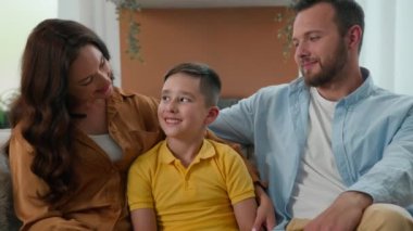 Gülümseyen Kafkasyalı aile babası, baba baba oğul çocuk kanepeye oturmuş, yeni anne-baba-baba pozu veriyor çocuk birlikte mutlu bir aile haftasonu geçiriyoruz kiralık ev kredisinde birlikte vakit geçiriyoruz.