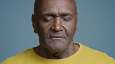 Yakın plan Afro-Amerikan atletik erkek sporcu erkek spor eğitmeni yoğun fitness egzersizinden sonra gözleri kapalı nefes alma egzersizi yapıyor.