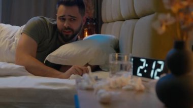 Kafkasyalı bir adam yatağında yatıyor. Hasta, uykusuzluk çeken, erkek yatak odasında alerji salgını, grip belirtileri, bağışıklık sistemi, solunum rahatsızlığı, bitkin düşmüş.